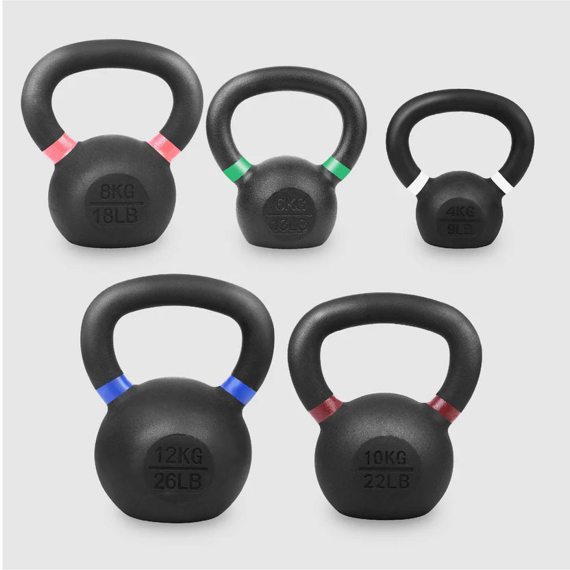 Set of five black kettlebells with weight markings on a light gray background